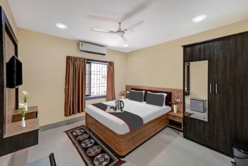 a bedroom with a large bed and a television at Goroomgo Moon Light Guest House Bhubaneswar Near Patia in Bhubaneshwar