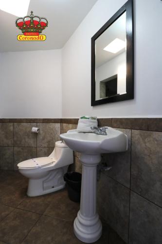 ein Badezimmer mit Waschbecken, Toilette und Spiegel in der Unterkunft Hotel Coronado in Ensenada