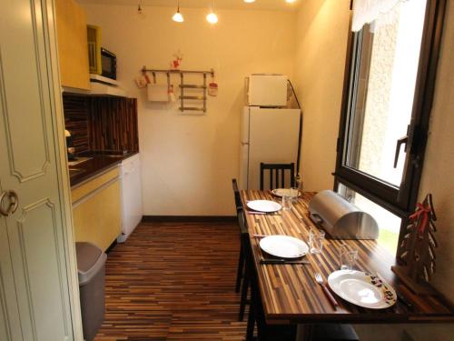 une cuisine avec une table en bois et un réfrigérateur dans l'établissement Luchon - Studio 2/3 pers., balcon, télécabine, proche commerces et thermes - FR-1-313-224, à Luchon