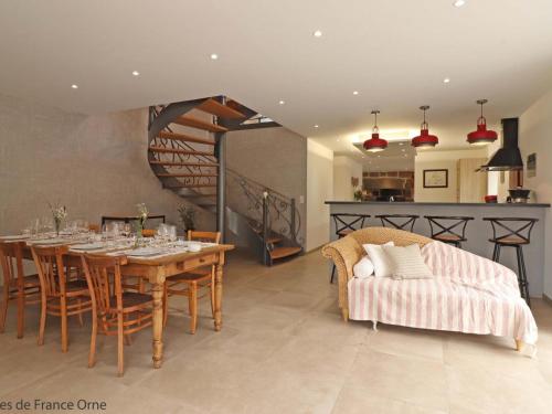ein Esszimmer mit Tisch und Couch in der Unterkunft Maison spacieuse avec bain nordique et mini ferme en Normandie - FR-1-497-187 in Saint-Patrice-du-Désert