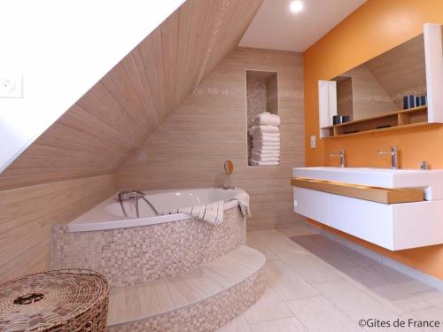 ein Badezimmer mit großer Badewanne und Waschbecken in der Unterkunft Maison spacieuse avec bain nordique et mini ferme en Normandie - FR-1-497-187 in Saint-Patrice-du-Désert