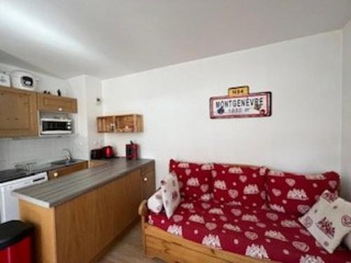 una cucina con divano rosso in una camera di Appartement Montgenèvre, 2 pièces, 5 personnes - FR-1-266-212 a Monginevro