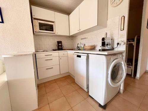 une cuisine avec un lave-linge et un lave-linge dans l'établissement Appartement climatisé 2 pièces cabine, 4 couchages, proche plage et centre, Cavalaire-sur-Mer - FR-1-226B-171, à Cavalaire-sur-Mer