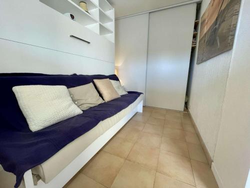 - une petite chambre avec un lit bleu et blanc dans l'établissement Appartement climatisé 2 pièces cabine, 4 couchages, proche plage et centre, Cavalaire-sur-Mer - FR-1-226B-171, à Cavalaire-sur-Mer