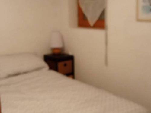 - une chambre avec un lit et une lampe sur une table de chevet dans l'établissement Appartement au centre, 40m², pied des pistes, télécabine, 1 chambre - FR-1-573-117, à Saint-Jean-dʼAulps