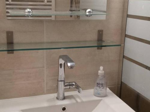 - un lavabo avec robinet et une bouteille de savon dans l'établissement Appartement au centre, 40m², pied des pistes, télécabine, 1 chambre - FR-1-573-117, à Saint-Jean-dʼAulps