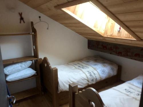 Cette chambre mansardée comprend 2 lits et une fenêtre. dans l'établissement Appartement Montgenèvre, 3 pièces, 4 personnes - FR-1-266-213, à Montgenèvre