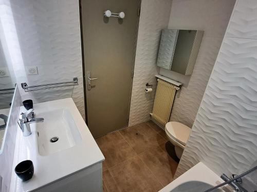 une salle de bain avec un lavabo blanc et des toilettes dans l'établissement **Duplex Rénové en Frond de Neige avec Terrasse et Equipements Modernes** - FR-1-165A-179, à Uvernet