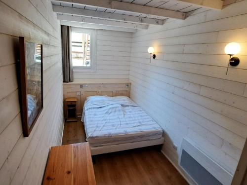 une petite pièce avec un lit et une fenêtre dans l'établissement **Duplex Rénové en Frond de Neige avec Terrasse et Equipements Modernes** - FR-1-165A-179, à Uvernet