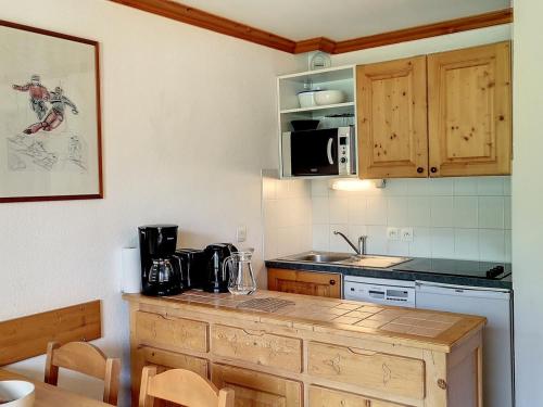 - une cuisine avec un comptoir et une cuisinière four supérieur dans l'établissement Appartement 2 pièces cosy aux Menuires, balcon sud-ouest, pied des pistes, proche commodités - FR-1-178-377, aux Bruyères