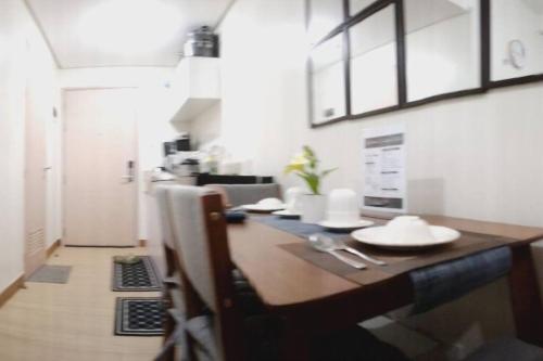 a dining room with a table with plates on it at Chelsea Suite's Esthetic Staycation at Trees Residence QC in Manila