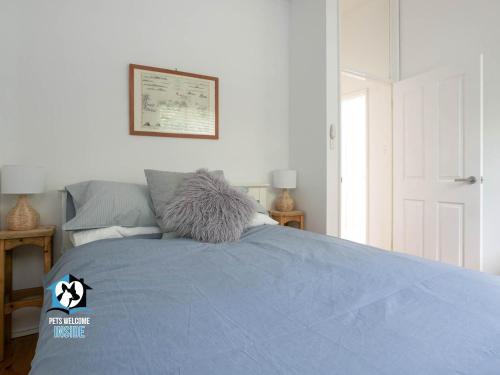 a bedroom with a bed with a blue comforter at 3BR Updated Coastal Beach House in Funky Port Elliot in Port Elliot