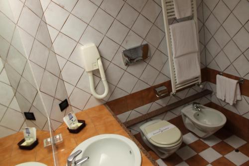 a bathroom with a sink and a toilet and a phone at Hotel Grillo in Assemini