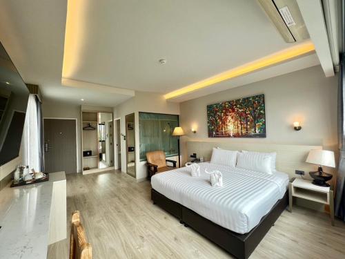 a bedroom with a large bed with a painting on the wall at Le Naview @Prasingh in Chiang Mai