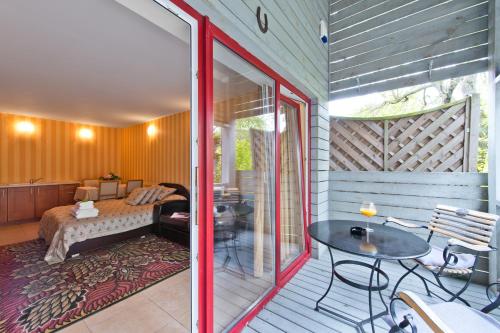 a bedroom with a bed and a table on a balcony at Vila Vika in Palanga