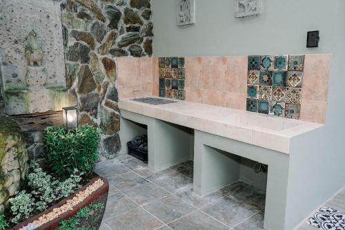 a bathroom with a stone wall with a bench at Casa Ferta in Pansol