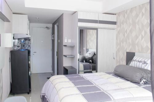 a bedroom with a large bed and a living room at Apartemen Skylounge Makassar in Makassar