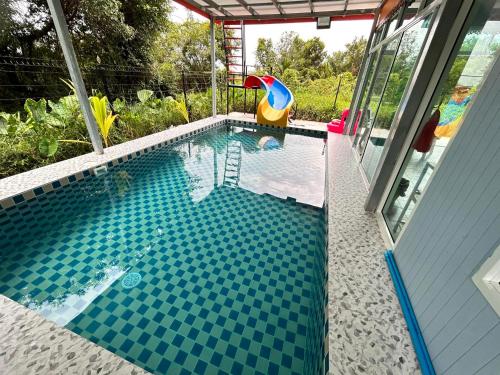 a swimming pool with blue tiles on the floor and a swimming toy at ปูณิสาวิลล่าPoonisavilla in Ban Khlong Kao (6)