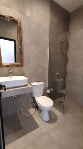 a bathroom with a toilet and a sink and a shower at Rabasta Enjoy Kuta in Denpasar