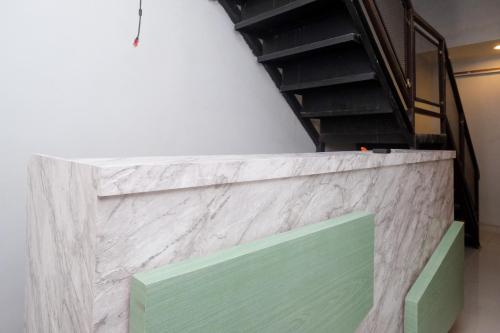a white and green wall with a staircase in a room at RedDoorz near Tentrem Mall Semarang in Semarang