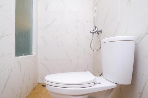 a white bathroom with a toilet and a shower at RedDoorz near Tentrem Mall Semarang in Semarang