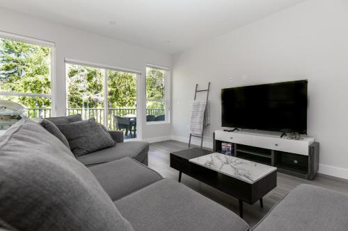a living room with a couch and a flat screen tv at Luxurious Home in Lake Cowichan in Lake Cowichan