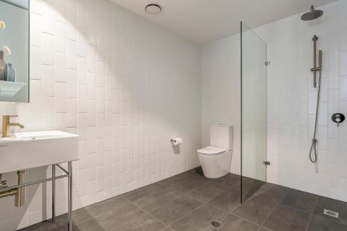 a bathroom with a toilet and a glass shower at Urban Rest Double Bay Apartments in Sydney