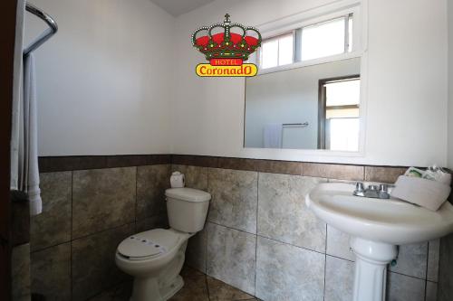 La salle de bains est pourvue de toilettes, d'un lavabo et d'un miroir. dans l'établissement Hotel Coronado, à Ensenada