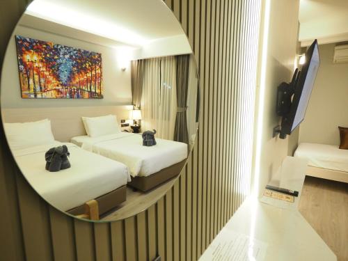 a hotel room with two beds and a mirror at Le Naview @Prasingh in Chiang Mai