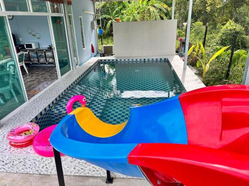a pool with a slide and a pool noodle pool at ปูณิสาวิลล่าPoonisavilla in Ban Khlong Kao (6)