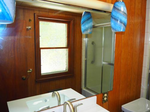 a bathroom with a sink and a mirror at Cavalier Cottage - Private Lakefront w Kayaks! in Honor