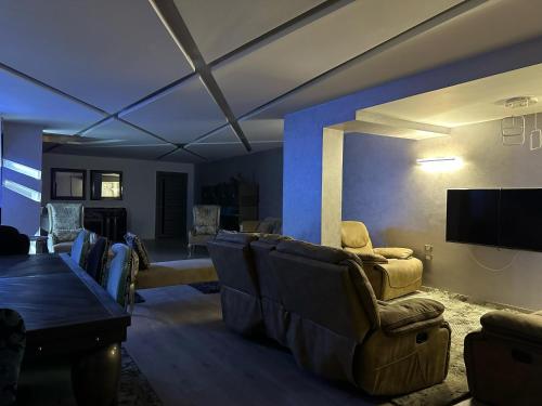 a living room with couches and a flat screen tv at Trio villa with falls in compound فلا بحديقة كبيره وشلالات صناعية in Sheikh Zayed