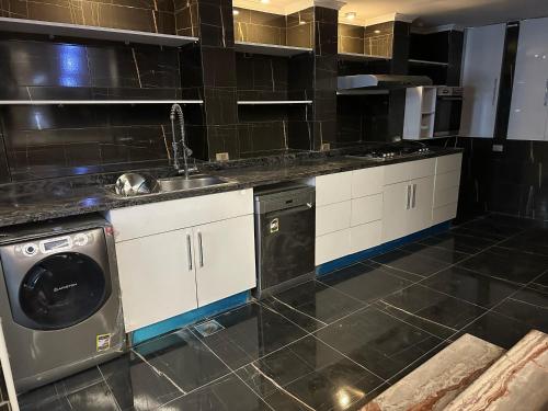 a kitchen with a sink and a washing machine at Trio villa with falls in compound فلا بحديقة كبيره وشلالات صناعية in Sheikh Zayed