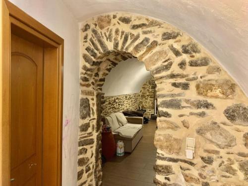 a stone hallway with a couch in a stone wall at Μεσαιωνικό σπιτι. in Mesta