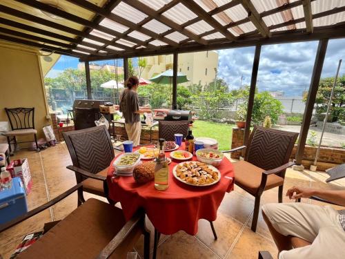 a table with food on a red table cloth at 北谷 vacation house MALAPUA in Chatan