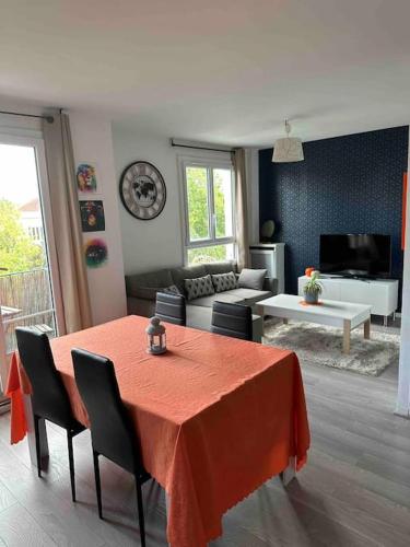 ein Wohnzimmer mit einem roten Tisch und Stühlen in der Unterkunft Spacieux T2 / verdure à Paris en 15min in Rueil-Malmaison