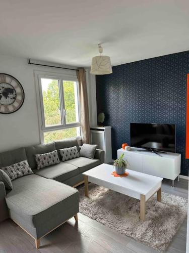 - un salon avec un canapé et une télévision dans l'établissement Spacieux T2 / verdure à Paris en 15min, à Rueil-Malmaison