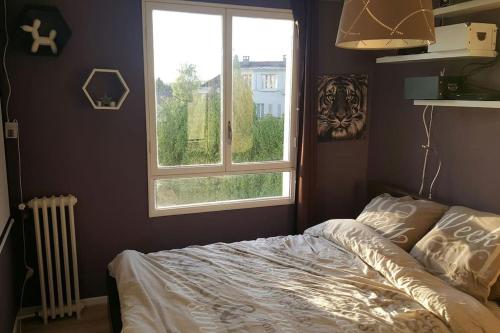 Schlafzimmer mit einem Bett und einem Fenster in der Unterkunft Spacieux T2 / verdure à Paris en 15min in Rueil-Malmaison