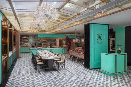 a dining room with tables and chairs and a chandelier at Hotel Indigo Guangzhou Haixinsha by IHG - Free Shuttle Bus to Canton Fair Complex during Canton Fair period in Guangzhou