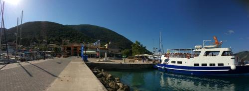 a boat is docked at a dock in the water at Orfeas Rooms in Vasiliki