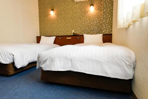 Una cama o camas en una habitación de Hotel Palms Tenmonkan