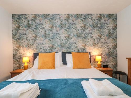 a bedroom with a bed with a floral wallpaper at Pebbles Foxglove Way in Bridport