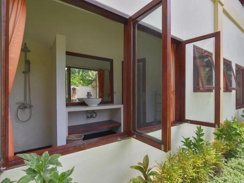 ein Badezimmer mit einem Spiegel und einem Waschbecken. in der Unterkunft Villa Singkenken in Kubutambahan