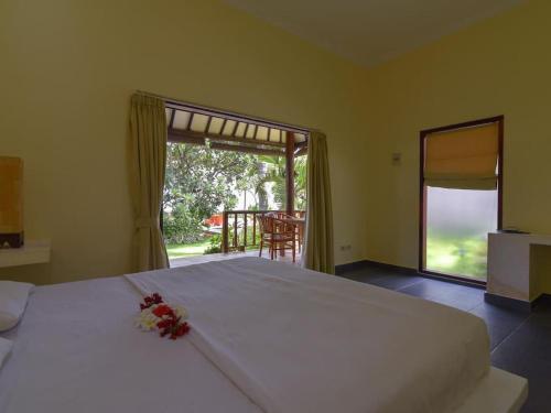 ein Schlafzimmer mit einem großen weißen Bett mit Blumen darauf in der Unterkunft Villa Singkenken in Kubutambahan