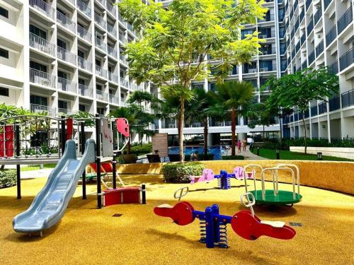 un parque infantil frente a un gran edificio en Simple but cozy 1BR Shore 2 MOA, en Manila