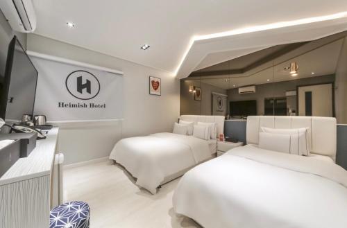 um quarto de hotel com duas camas num quarto em Heimish Hotel em Tongyeong
