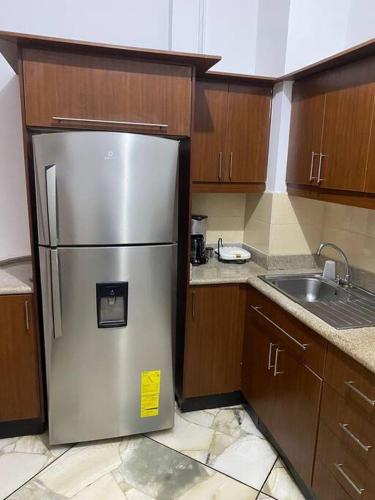 a kitchen with a stainless steel refrigerator and a sink at Departamento Cómodo Frente a la Playa in Manta