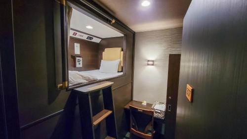 Habitación pequeña con espejo y cama en Hotel Palms Tenmonkan, en Kagoshima