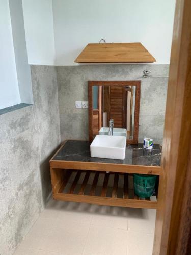 a bathroom with a sink and a mirror at Panopano House in Nungwi