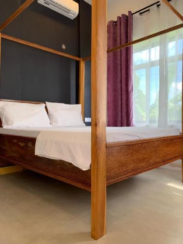 ein Schlafzimmer mit einem Etagenbett aus Holz und einem Fenster in der Unterkunft Panopano House in Nungwi